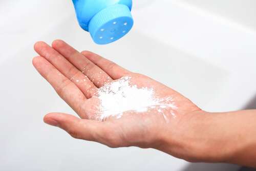 A woman using talcum powder and putting herself at risk for ovarian cancer.