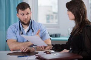 Defensive doctor talking to female lawyer.