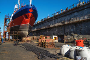 Ship with an anchor and chains for repair in a dry dock.