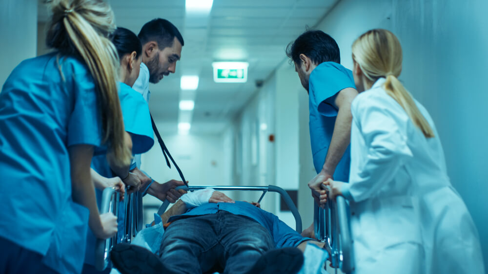 Doctor and nurses rushing critical patient to emergency room.