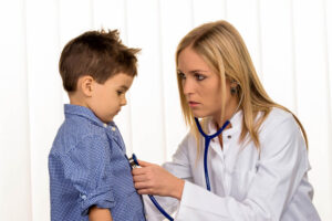 Pediatrician  checking up boy's health.