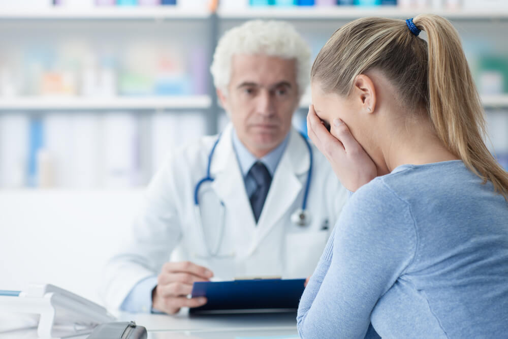 Doctor giving sad news to woman patient.