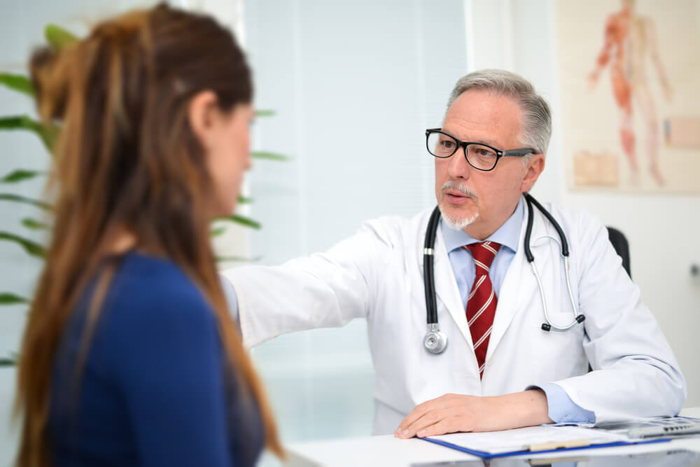 Doctor talking to female patient regarding her diagnosis.