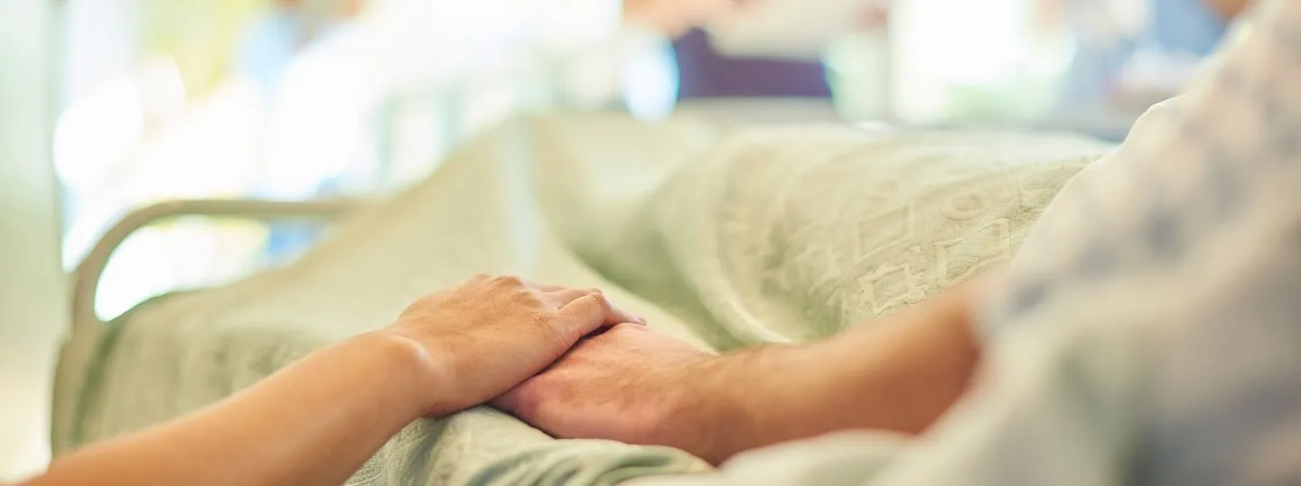 Hospital patient holding relatives hand